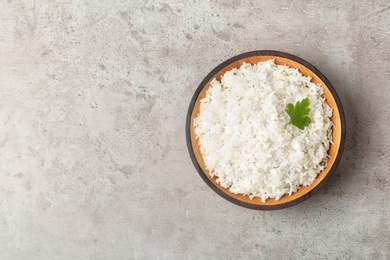 Photo of Bowl of boiled rice on grey background, top view with space for text