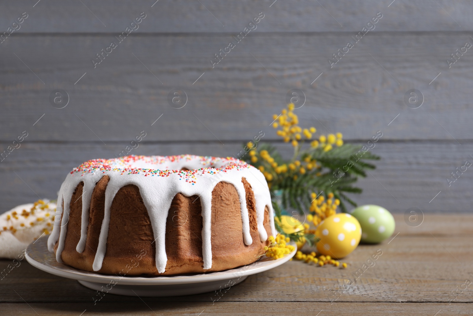 Photo of Glazed Easter cake with sprinkles on wooden table, space for text