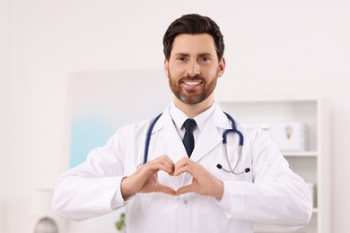 Doctor showing heart gesture with hands in clinic