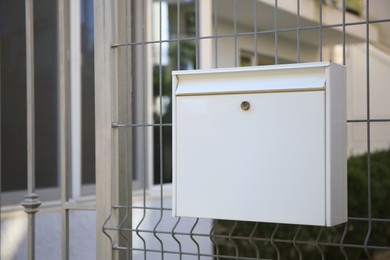 White metal letter box on fence outdoors