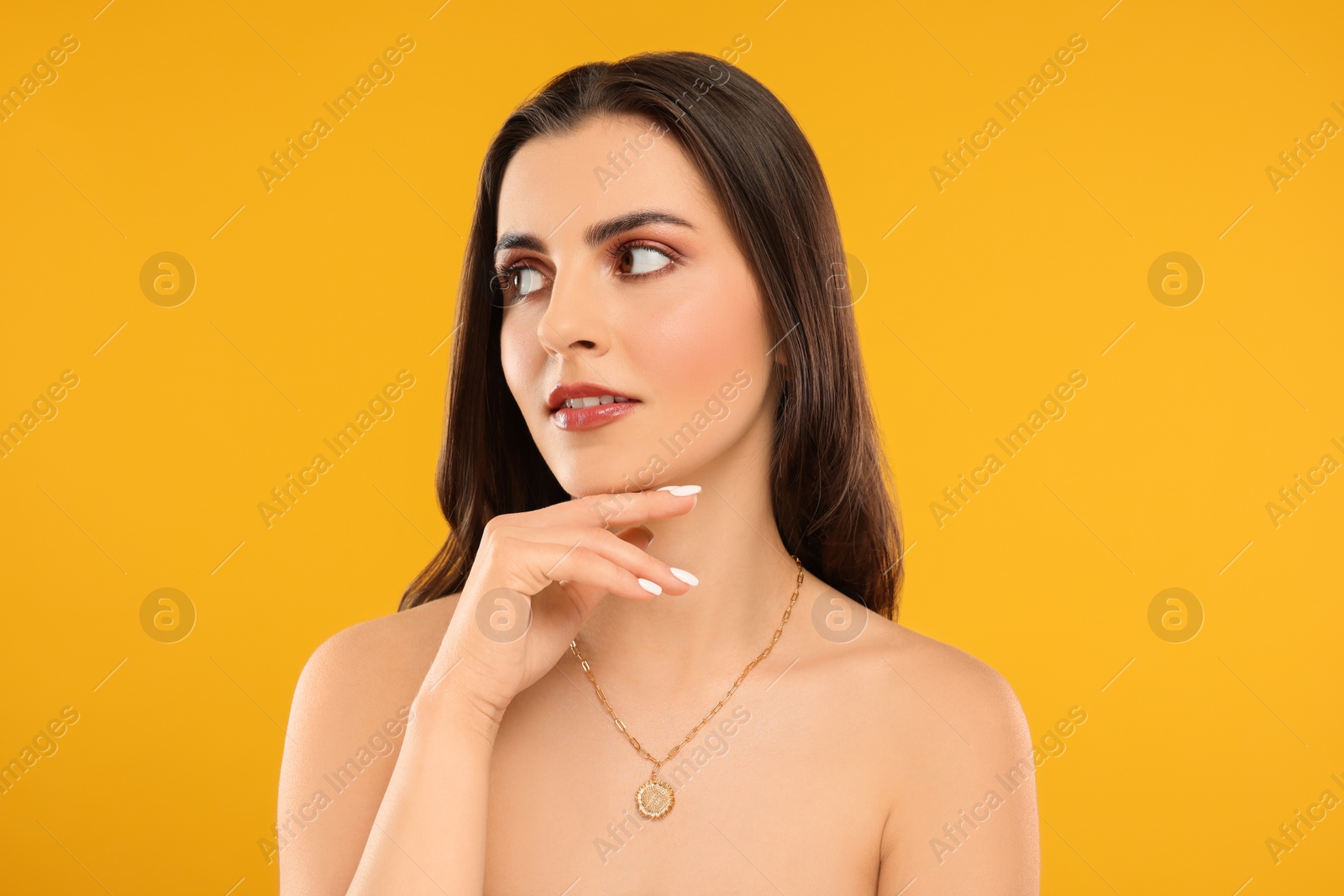 Photo of Beautiful woman with elegant necklace on orange background