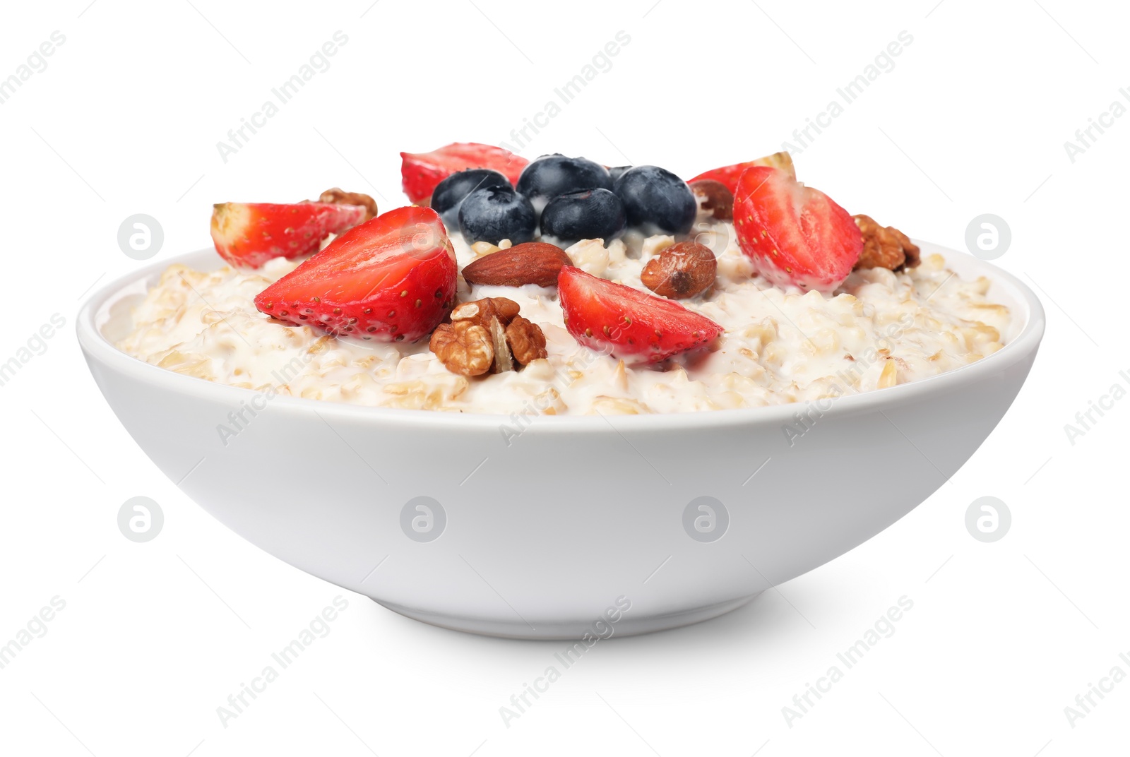 Photo of Tasty boiled oatmeal with berries and nuts in bowl isolated on white