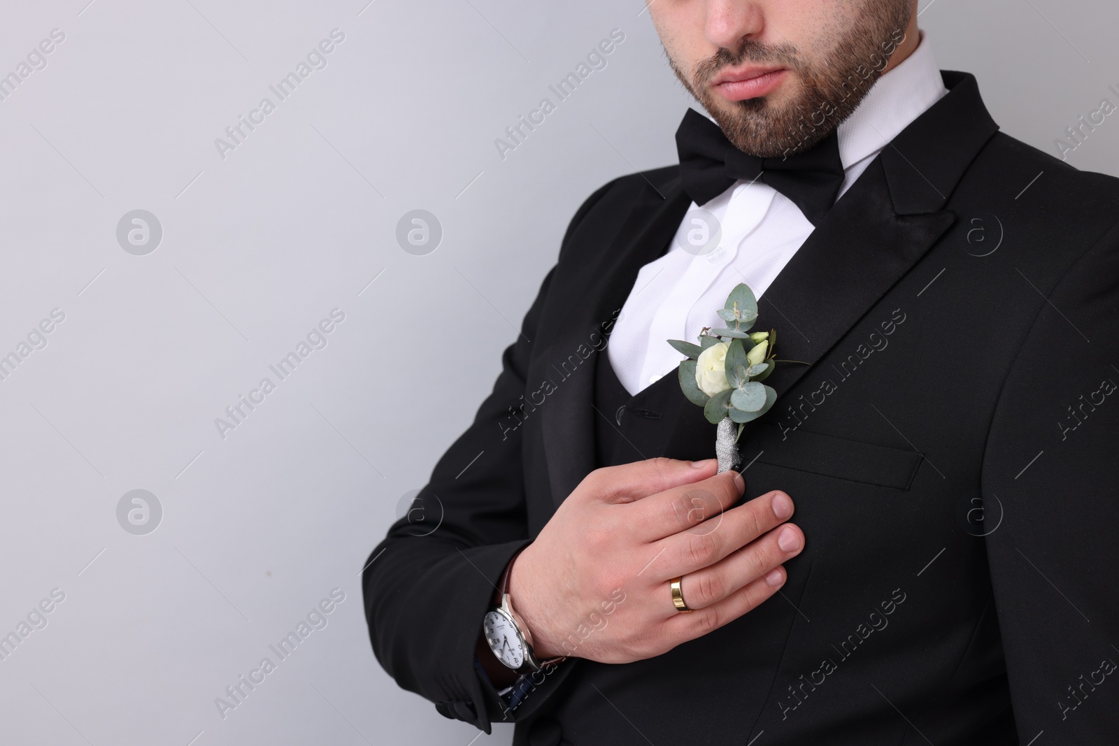 Photo of Groom with boutonniere on light grey background, closeup and space for text. Wedding accessory