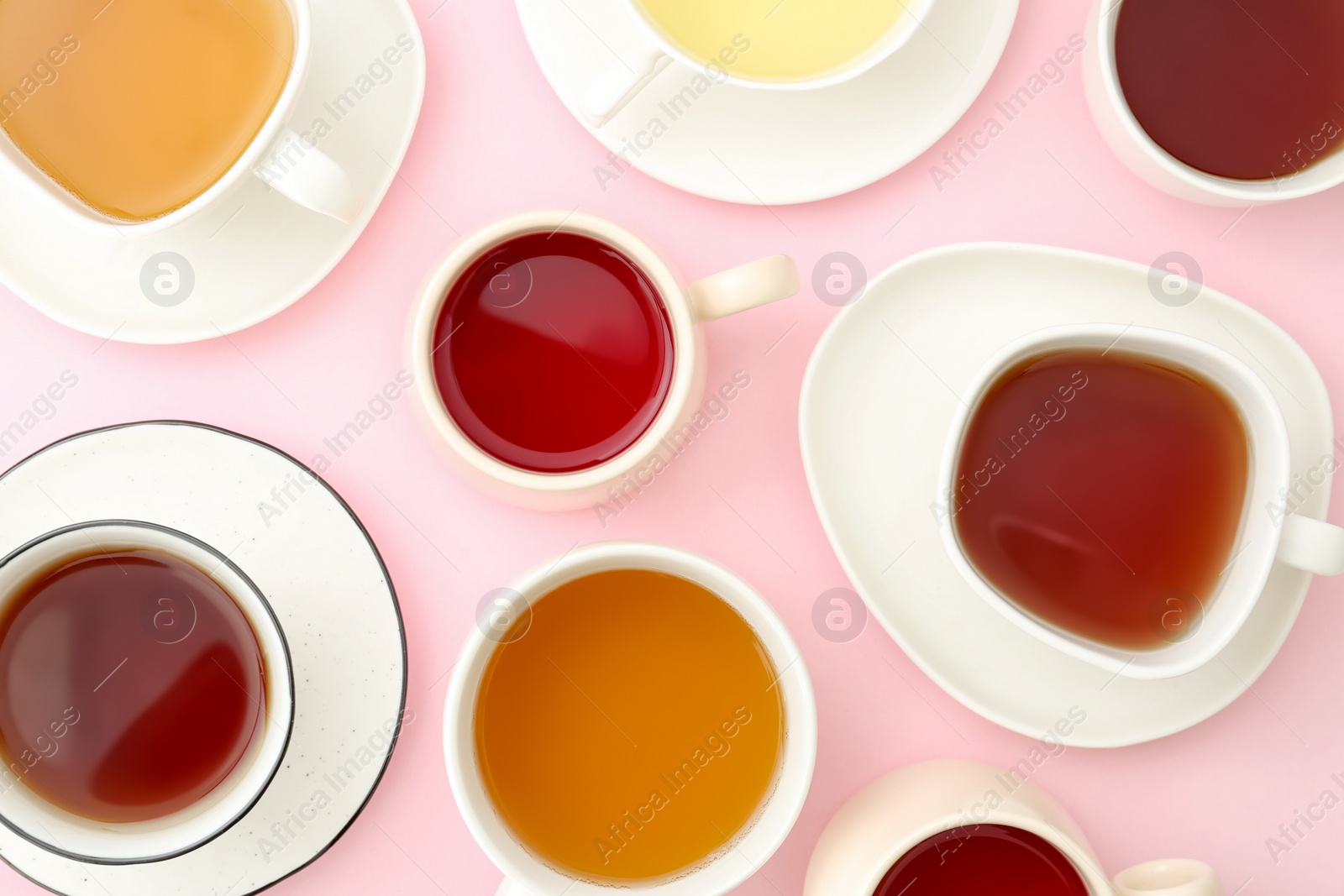 Photo of Cups with different types of tea on pink background, flat lay