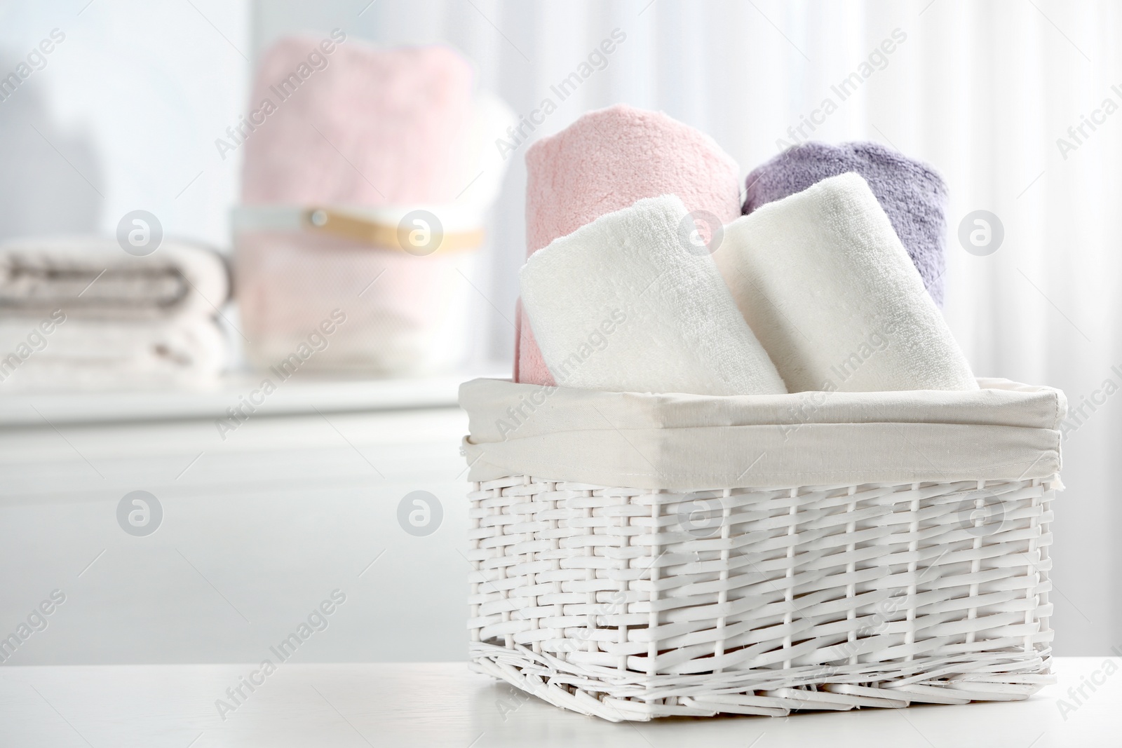 Photo of Basket of fresh towels on table. Space for text