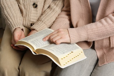 Photo of Women reading Bible together, closeup. Religious literature