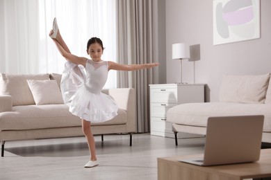 Photo of Cute little girl taking online dance class at home