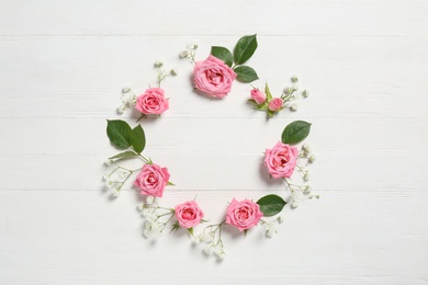 Photo of Flat lay composition with beautiful roses on white wooden background, space for text