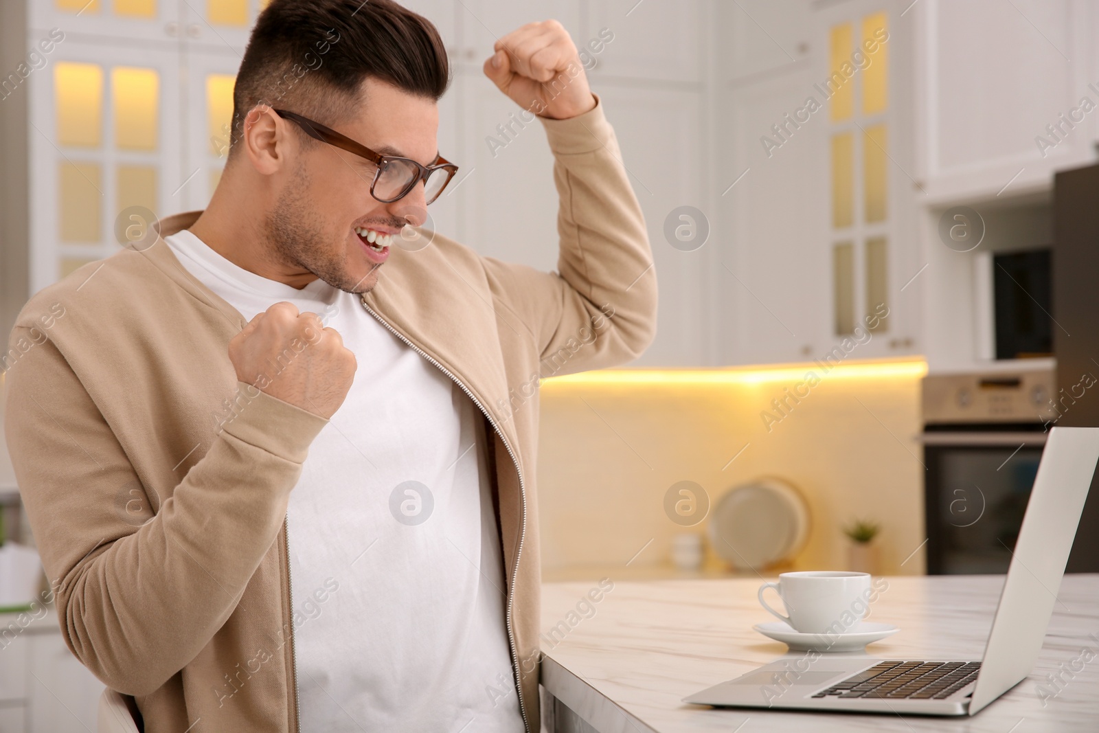 Photo of Emotional man participating in online auction using laptop at home