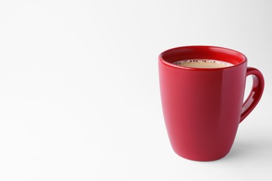 Photo of Red mug of freshly brewed hot coffee on white background, space for text