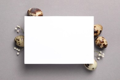 Photo of Speckled quail eggs and blank card on light grey background, flat lay. Space for text