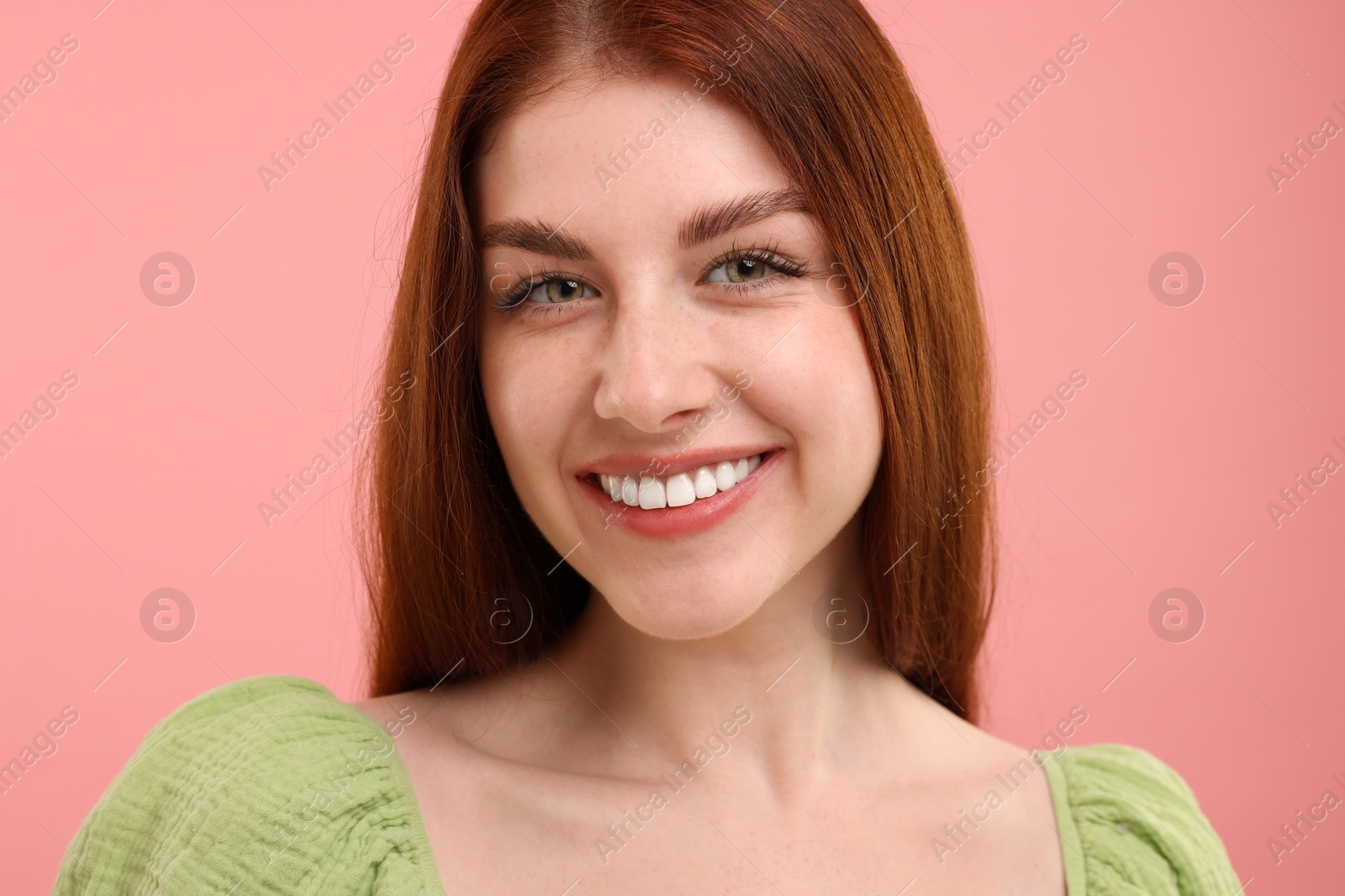 Photo of Portrait of smiling woman with freckles on pink background