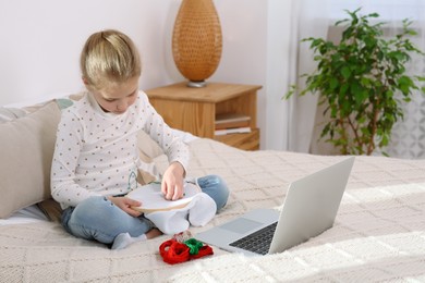 Photo of Little girl learning to embroider with online course at home. Space for text