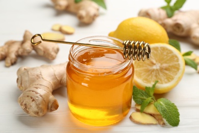 Photo of Honey, ginger and lemon on white wooden table. Natural cold remedies