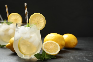 Natural lemonade with mint on grey table against black background, space for text. Summer refreshing drink