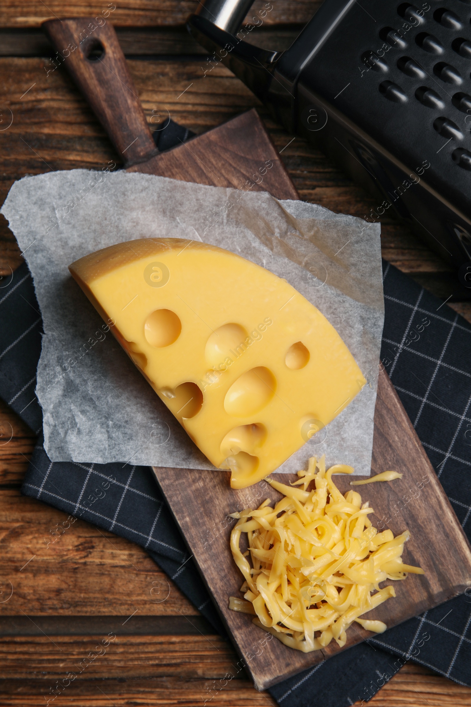 Photo of Tasty grated cheese on wooden table, flat lay