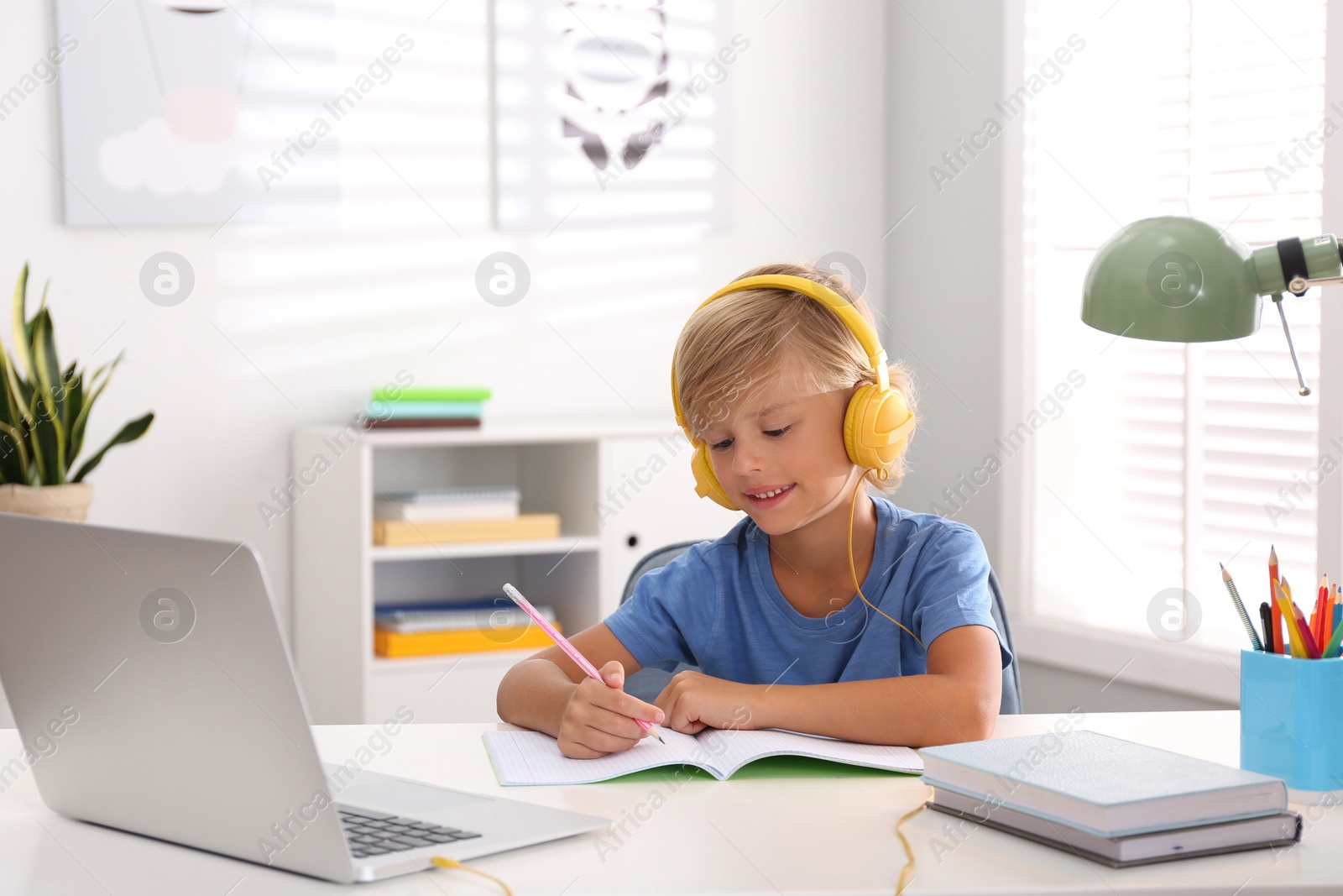 Photo of Little boy studying online at home. Distance learning during COVID-19 pandemic