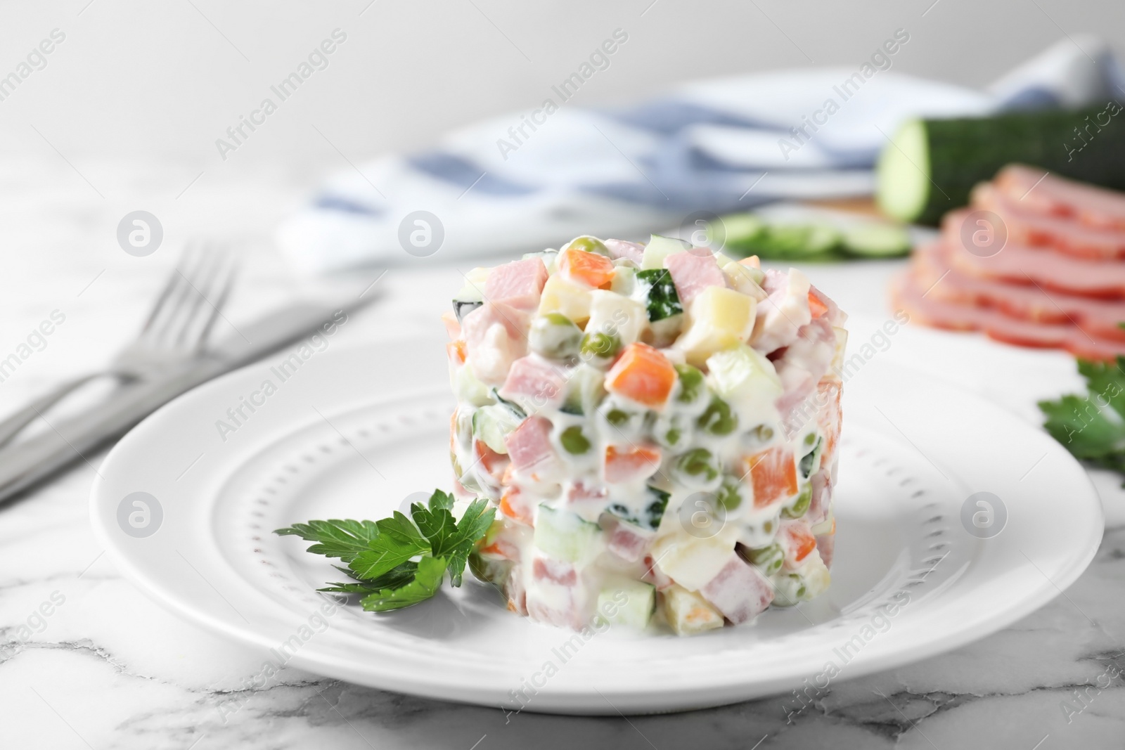 Photo of Delicious homemade salad Olivier on marble table