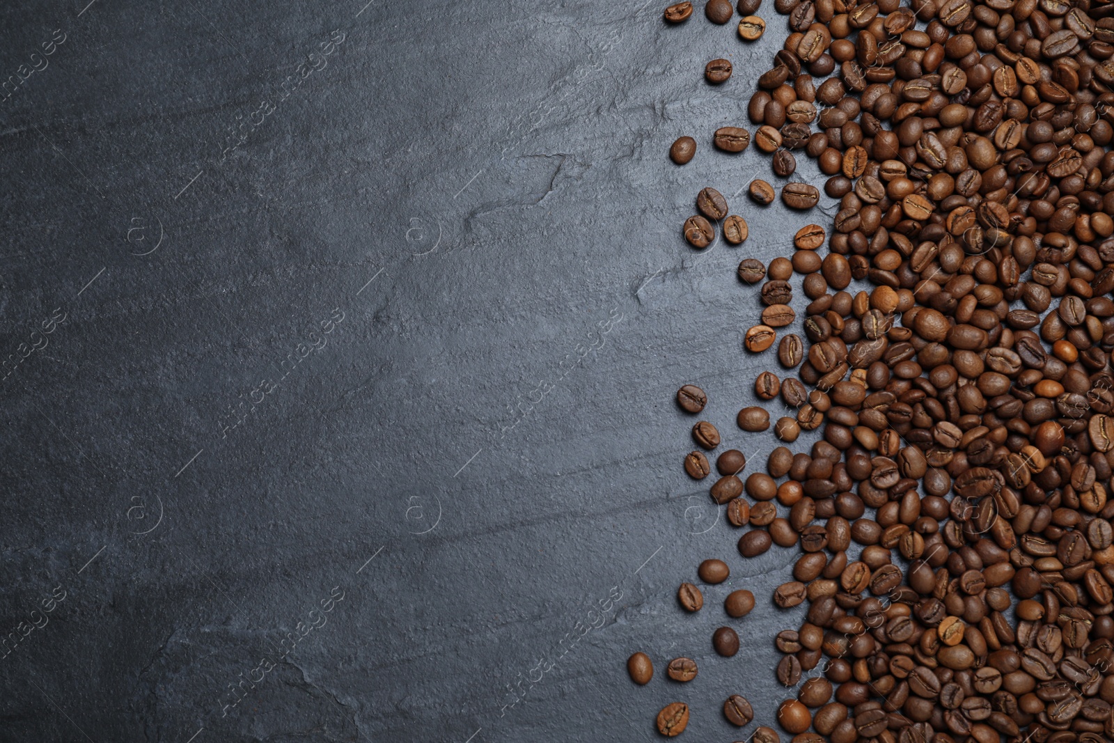 Photo of Many roasted coffee beans on black table, flat lay. Space for text