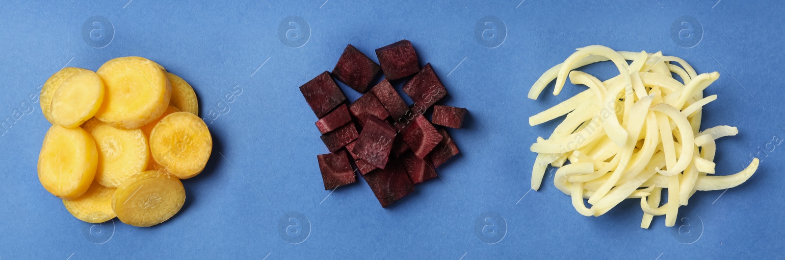 Photo of Cut raw color carrots on blue background, flat lay