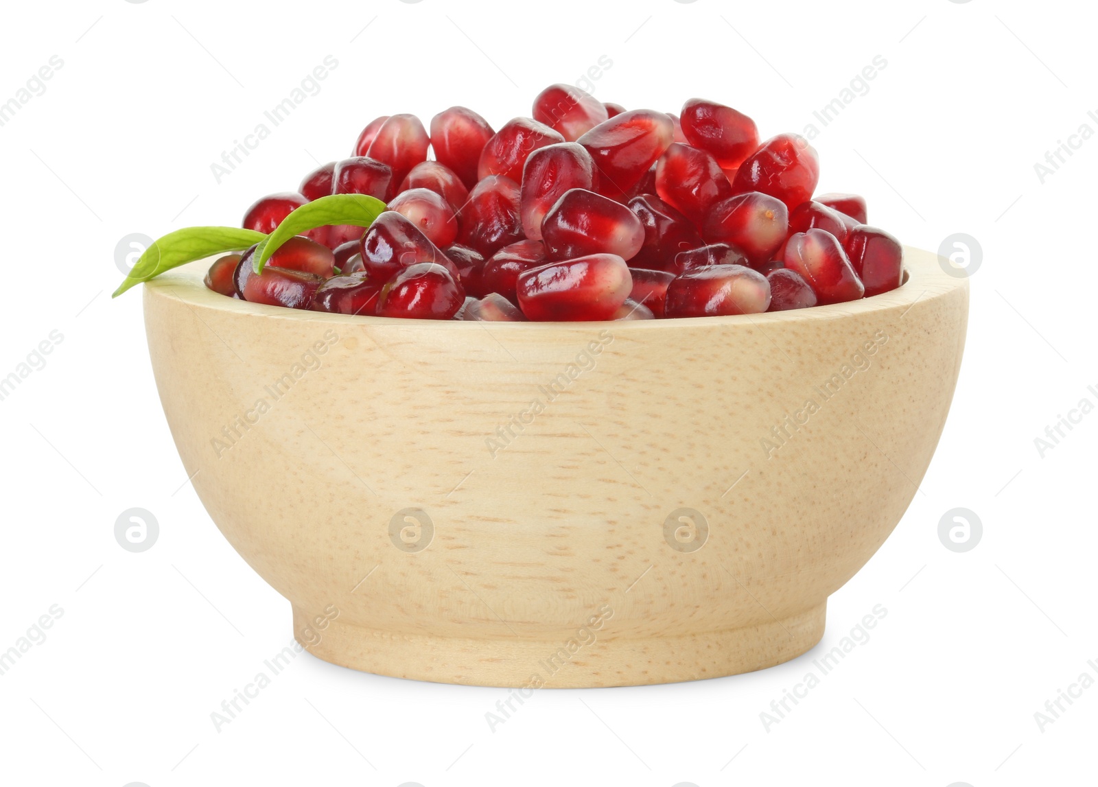 Photo of Ripe juicy pomegranate grains and leaves in wooden bowl isolated on white