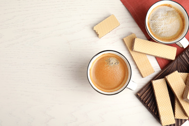 Breakfast with delicious wafers and coffee on white wooden table, flat lay. Space for text