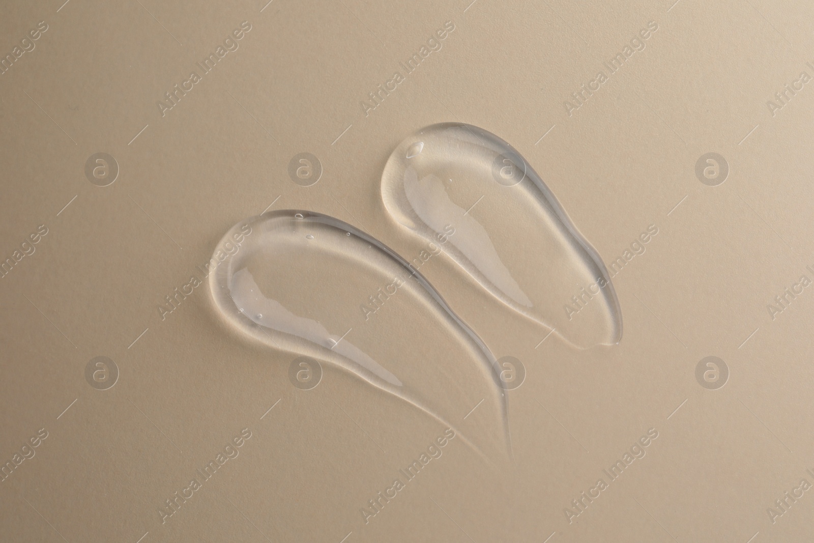 Photo of Sample of transparent gel on beige background, top view