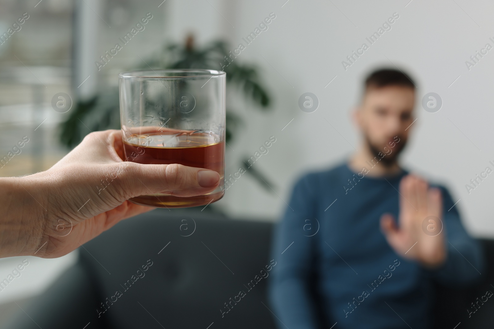 Photo of Man refusing to drink whiskey indoors, closeup. Alcohol addiction treatment