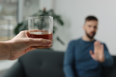 Man refusing to drink whiskey indoors, closeup. Alcohol addiction treatment