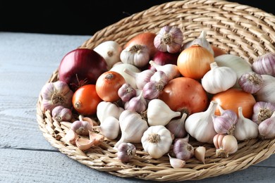 Photo of Fresh raw garlic and onions on gray wooden table