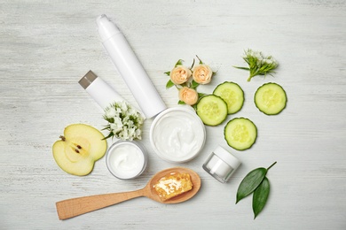 Photo of Beautiful composition with cosmetics, flowers and products on white wooden background, flat lay