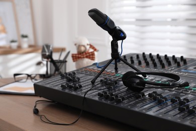 Professional audio equipment on wooden table in modern radio studio