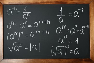 Photo of Many different math formulas written on chalkboard, closeup