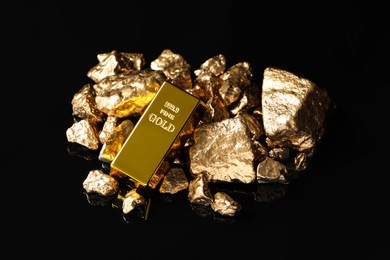 Photo of Gold ingot and nuggets on black background