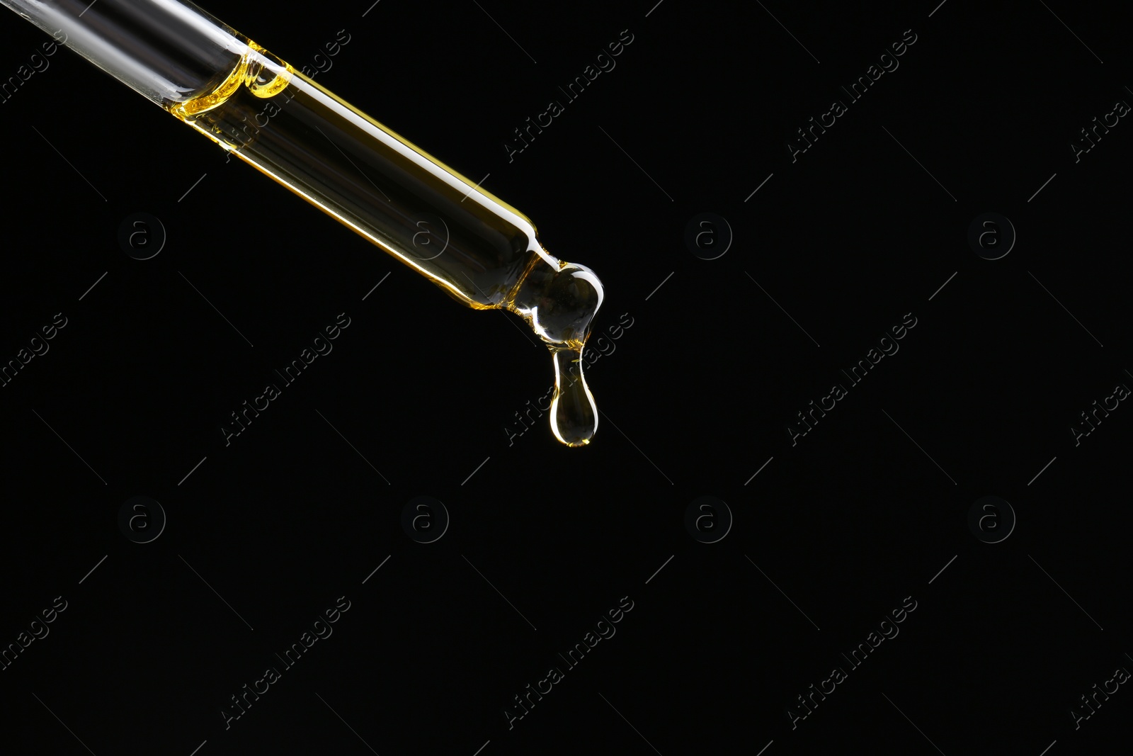 Photo of Dripping tincture from pipette on black background, closeup. Space for text