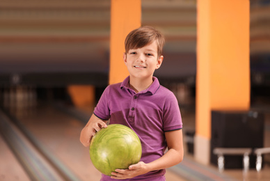 Photo of Preteen boy with ball in bowling club