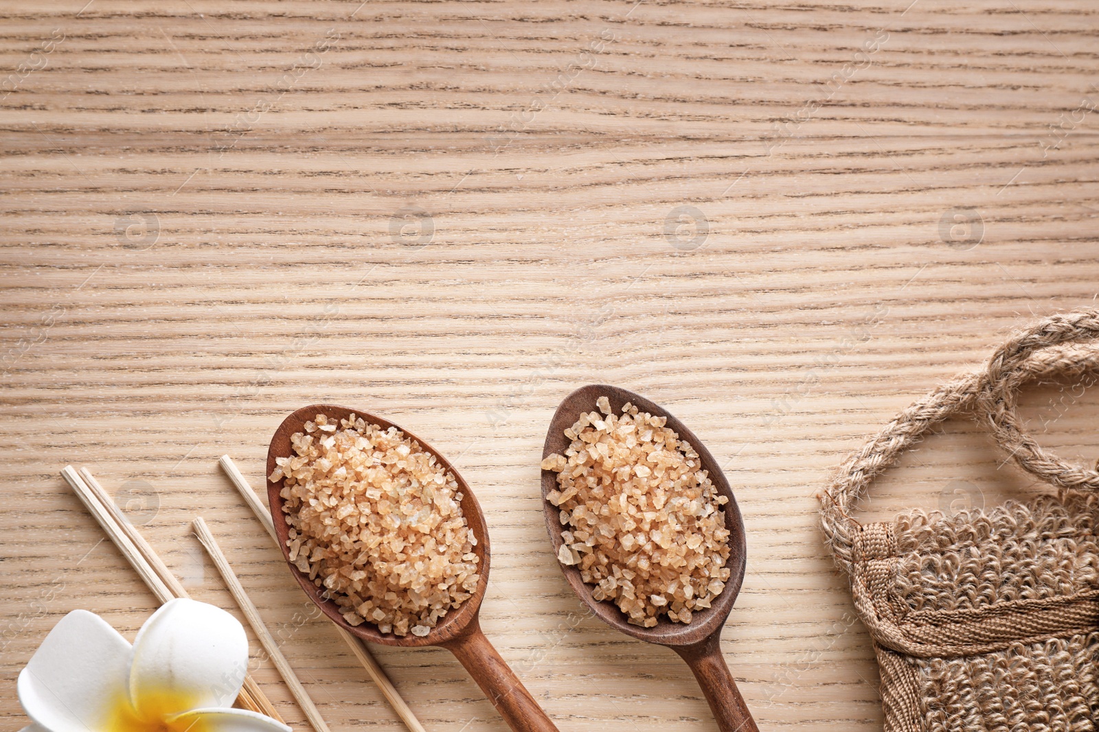 Photo of Flat lay composition with brown sea salt on wooden background, space for text. Spa treatment