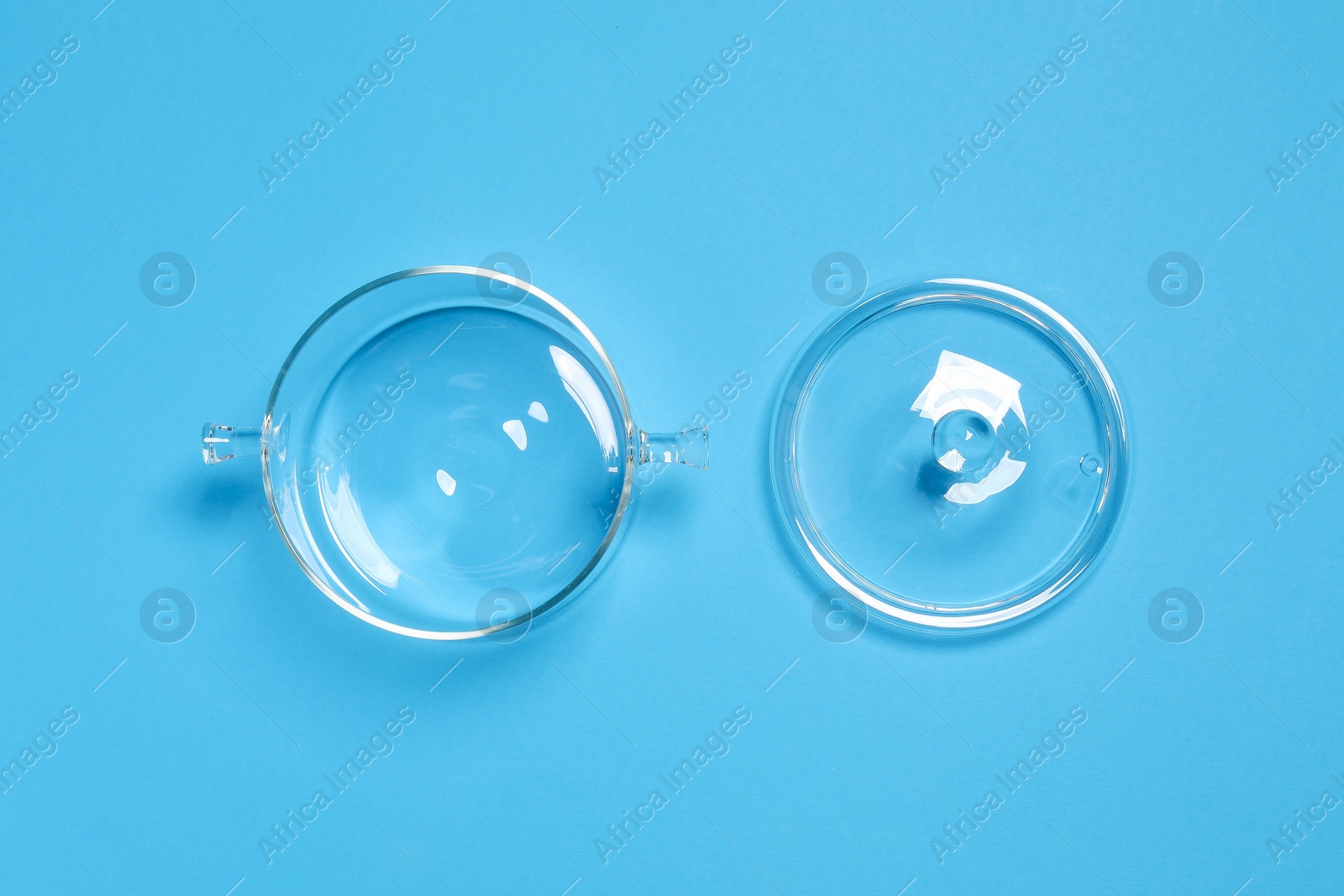Photo of Empty glass pot and lid on light blue background, flat lay