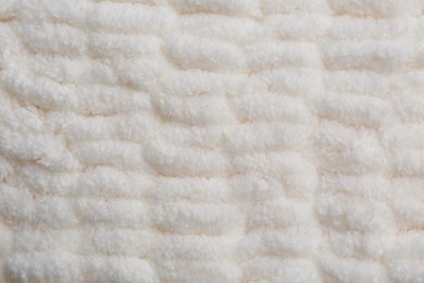 Photo of Soft white knitted fabric as background, top view