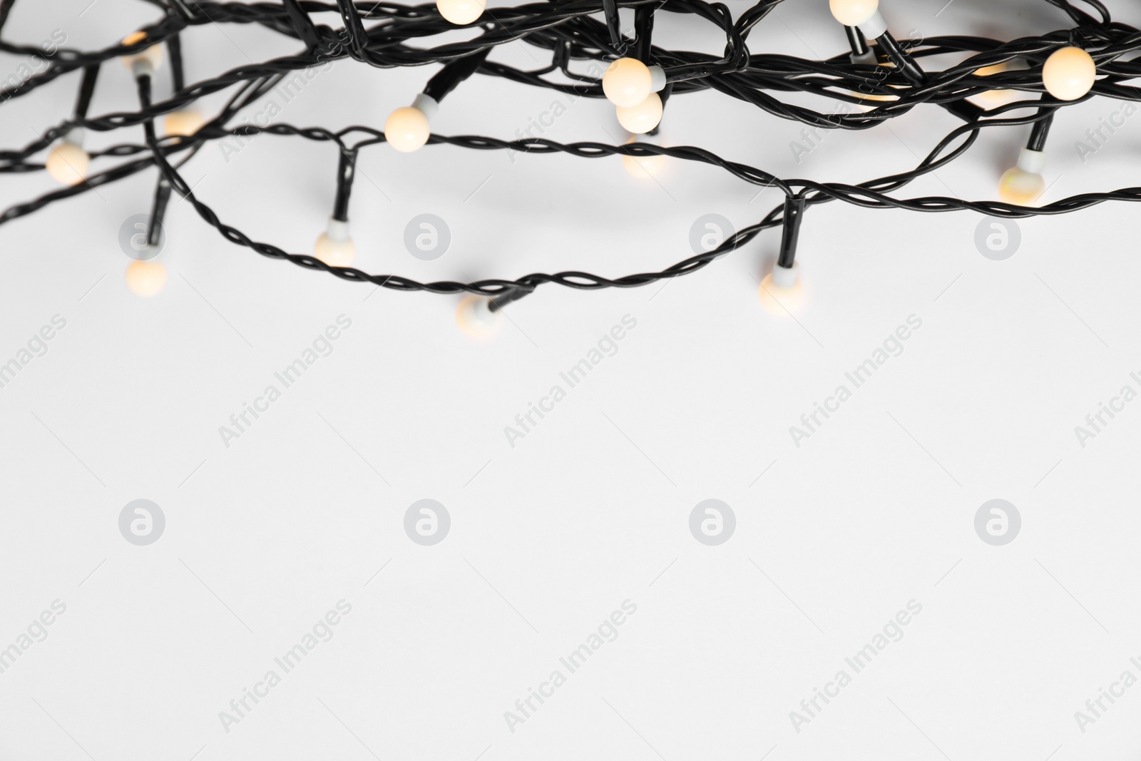 Photo of Beautiful Christmas lights on white background, top view