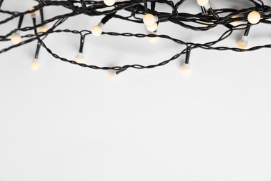 Beautiful Christmas lights on white background, top view