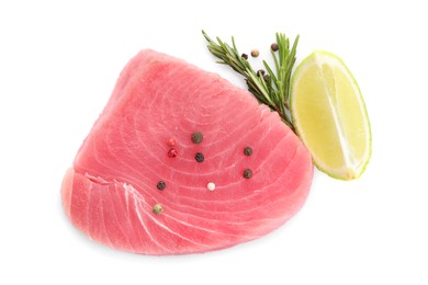 Photo of Raw tuna fillet with spices and lime wedge on white background, top view