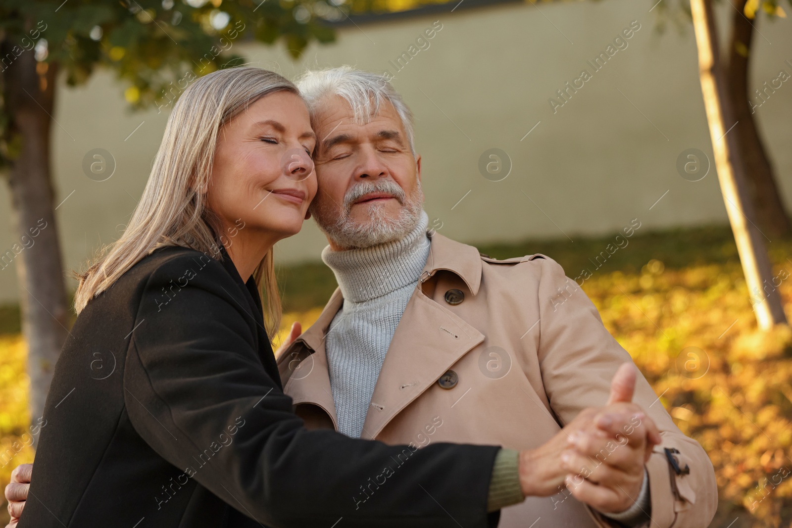 Photo of Affectionate senior couple dancing together outdoors. Romantic date