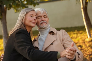 Affectionate senior couple dancing together outdoors. Romantic date