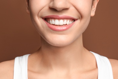 Young woman with beautiful smile on color background. Teeth whitening