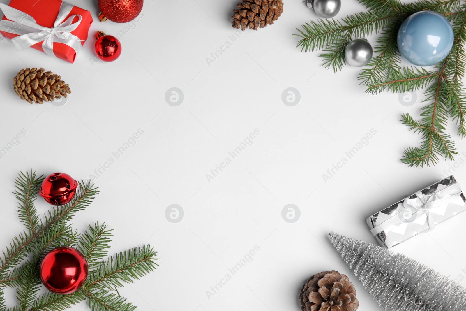 Photo of Christmas greeting card with space for text. Flat lay composition of fir tree branches and festive decor on white background