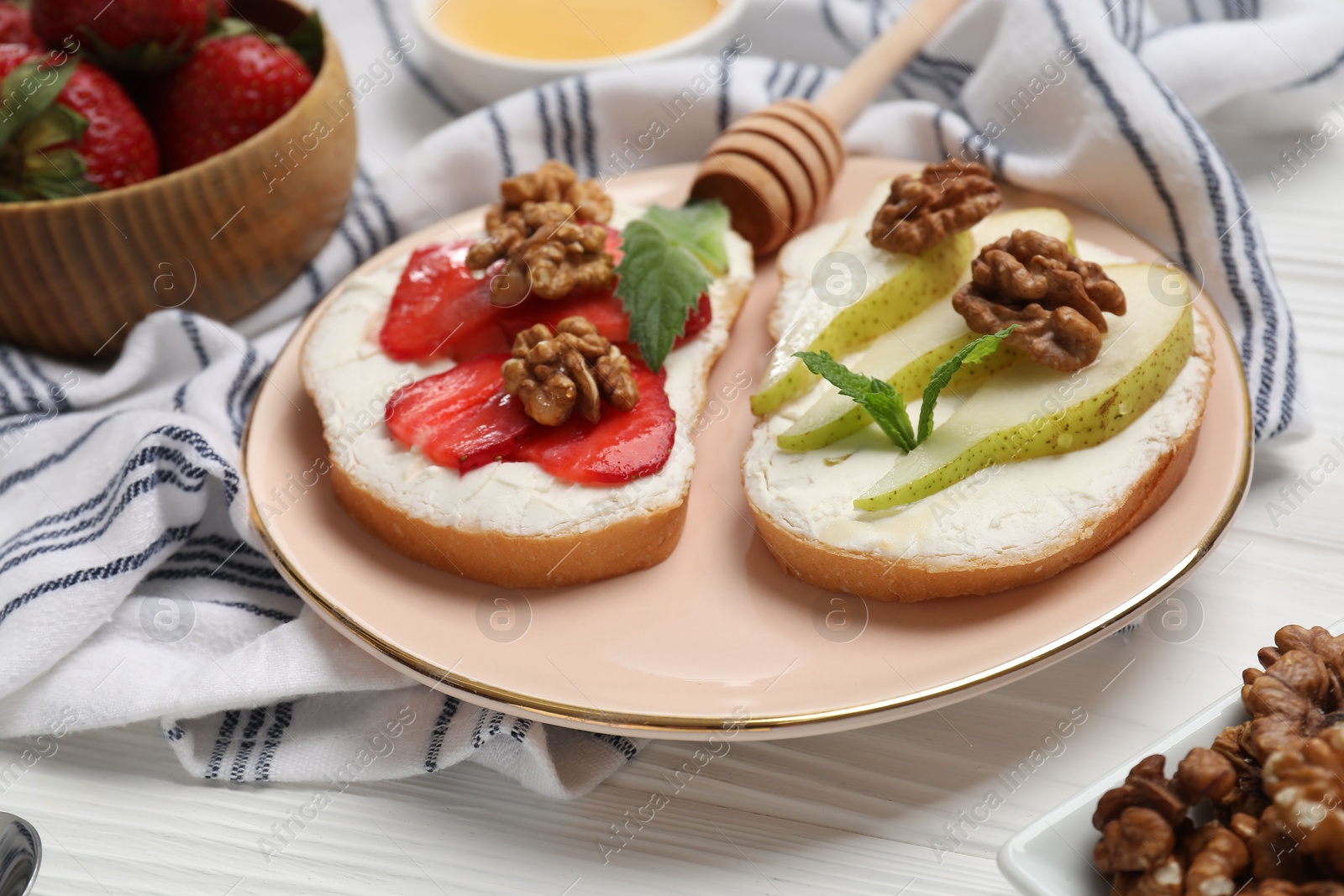 Photo of Plate with different tasty ricotta bruschettas on white wooden table, closeup