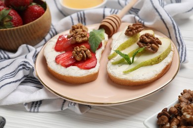 Photo of Plate with different tasty ricotta bruschettas on white wooden table, closeup