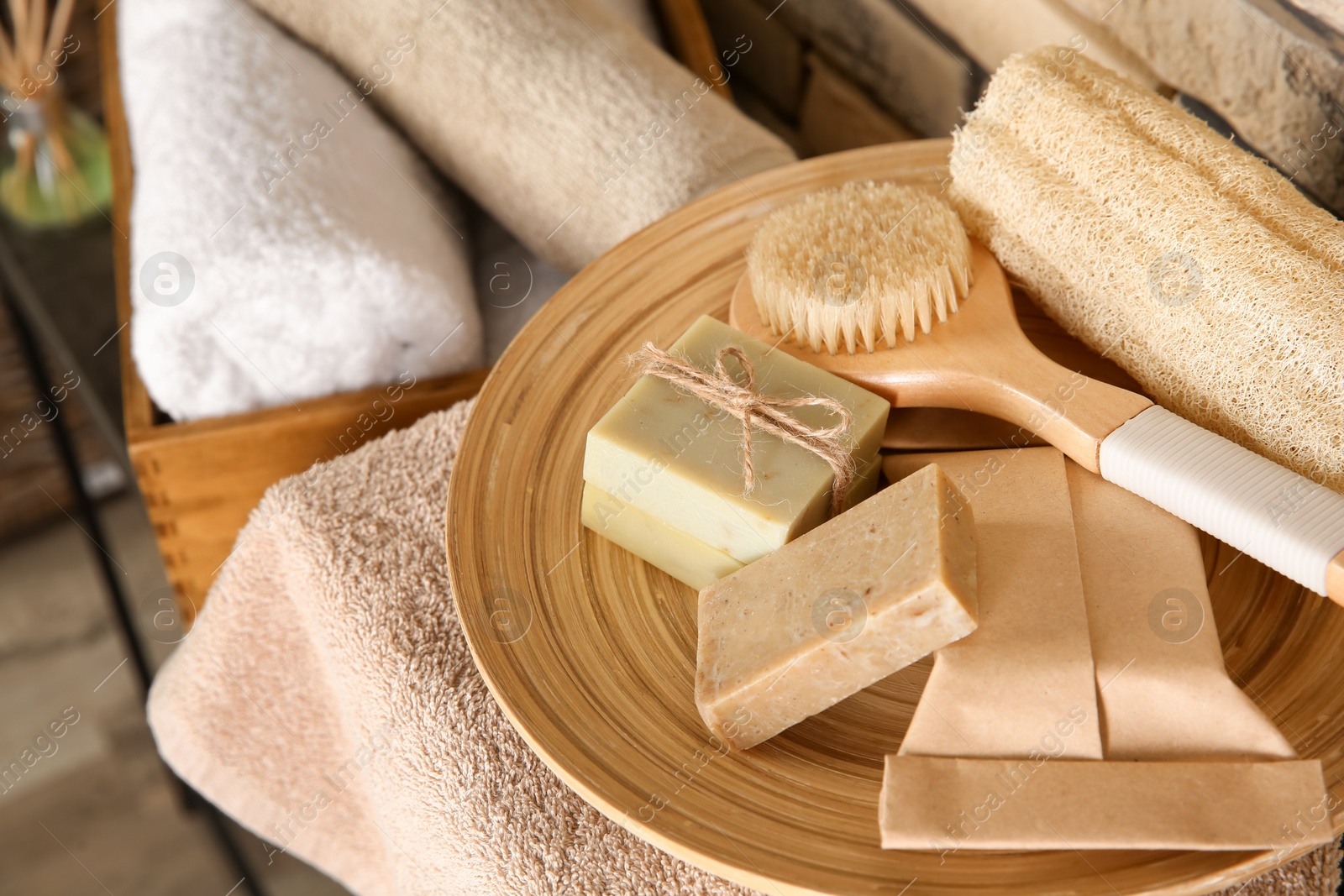 Photo of Plate with brush, wisp and handmade soap bars on table, closeup. Space for text