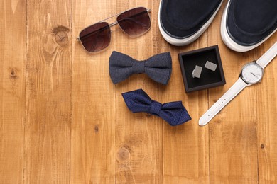 Photo of Flat lay composition with stylish color bow ties on wooden background. Space for text